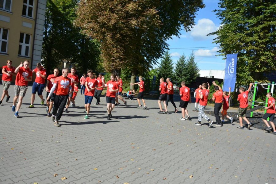grupa młodzieży biega przed budynkiem